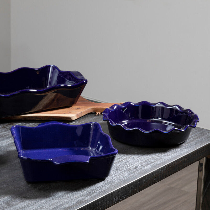 Set of blue ceramic dishes on a wooden table with a neutral background