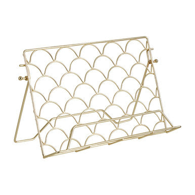 Gold metal magazine rack with a scalloped design on a white background