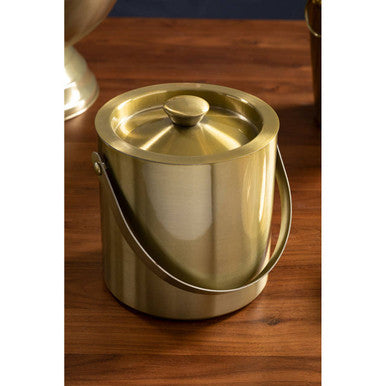 Gold-colored metal ice bucket on a wooden surface