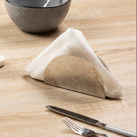 Table setting with ceramic bowls, metal cups, and a tea bag on a wooden surface.