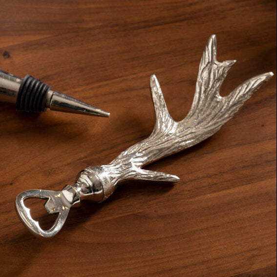 Silver antler-shaped bottle opener and cork retriever on a wooden surface
