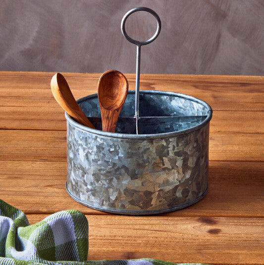 Metal container with wooden spoons on a wooden surface