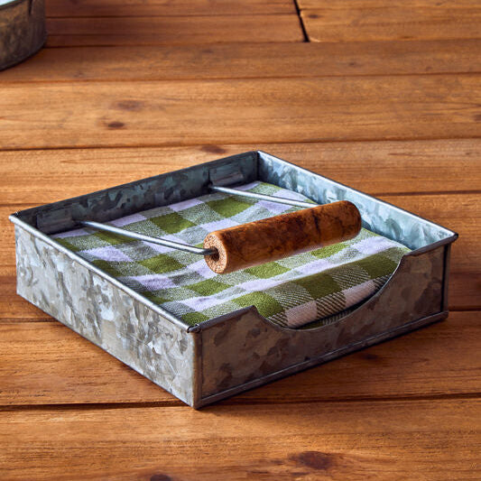 Metal tray with green patterned cloth and wooden rolling pin on a wooden surface