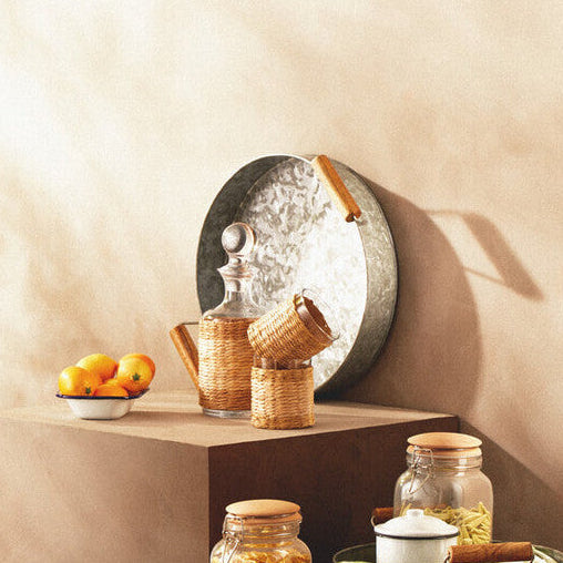 Decorative setup with a wooden tiered stand, jars, and a mirror on a beige background
