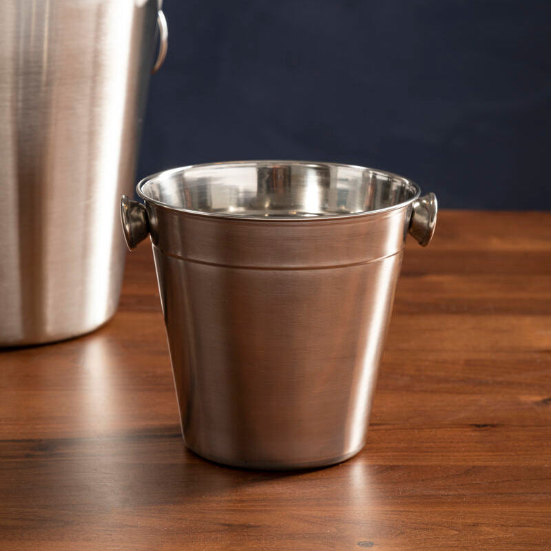Two metallic ice buckets on a wooden surface with a dark background