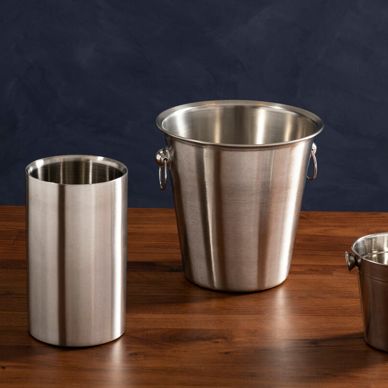 Three metallic wine coolers of different sizes on a wooden surface with a dark background