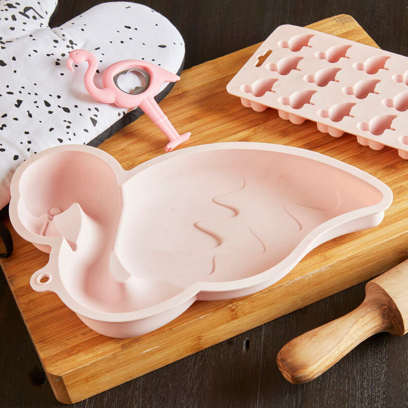 Pink silicone ice cube tray and mold on a wooden cutting board with a rolling pin.