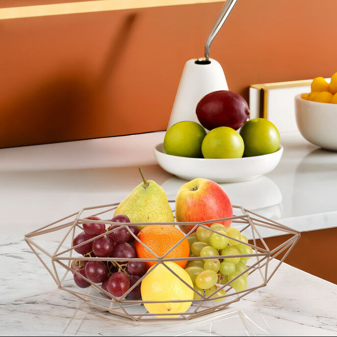 Fruit bowl with apples, pears, and grapes on a marble countertop with a brown wall background.