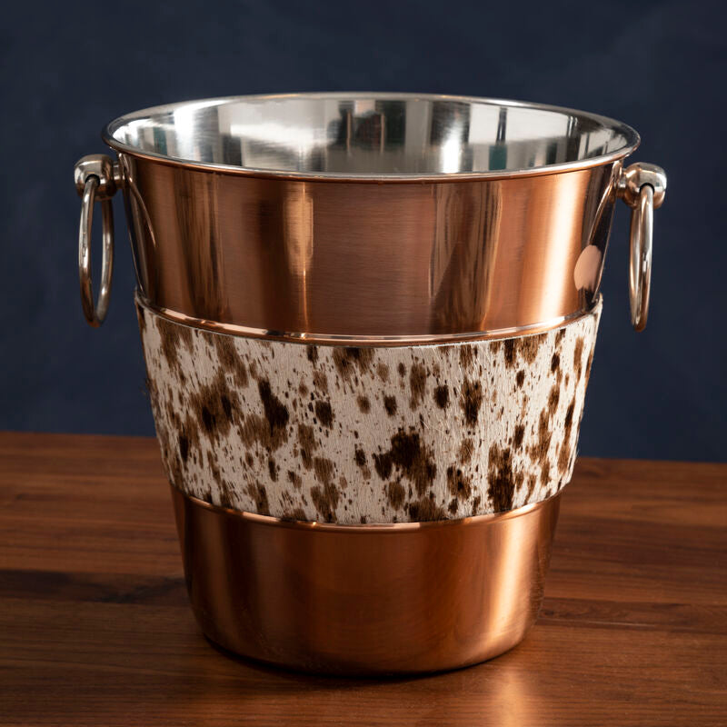 Copper ice bucket with speckled pattern on a wooden surface
