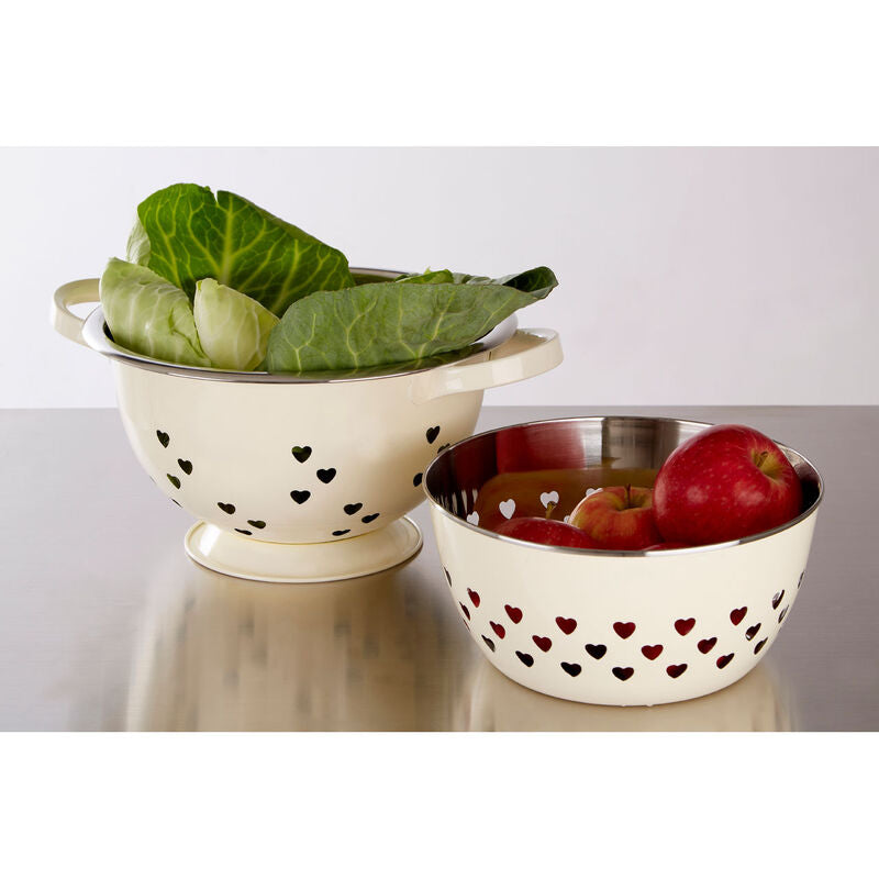 Two ceramic bowls with heart and dot patterns on a reflective surface.