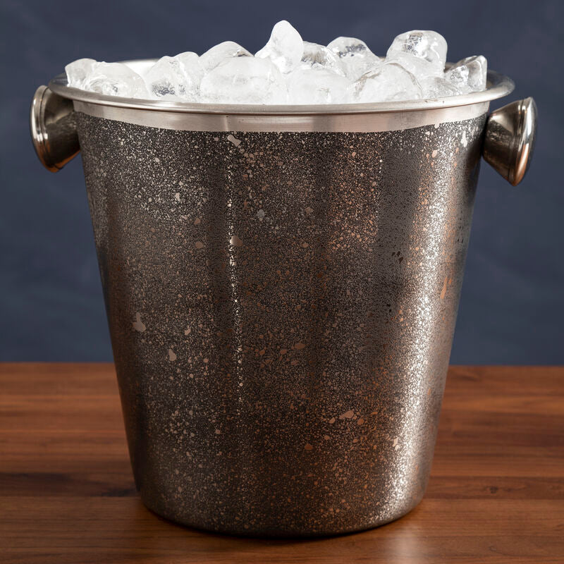 Vintage-style ice bucket filled with ice on a wooden surface with a dark background