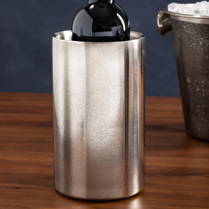 Wine bottle in a metallic ice bucket on a wooden surface with a dark background