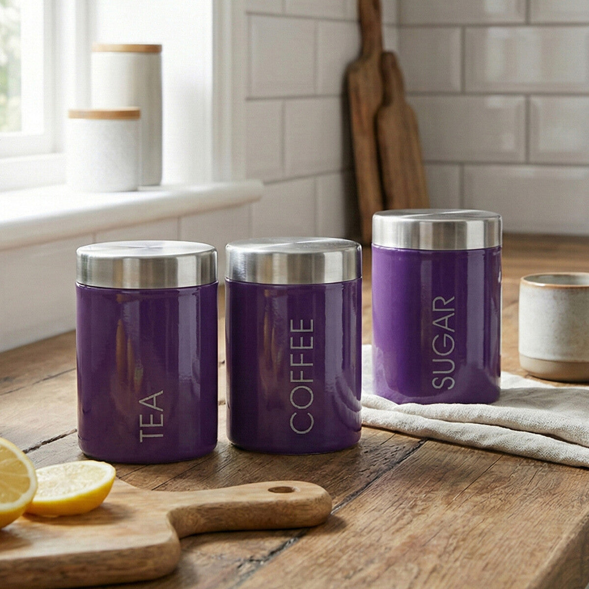 Three purple kitchen canisters labeled &