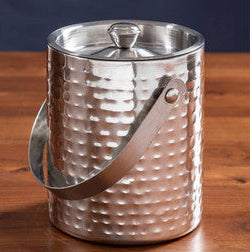 Silver hammered ice bucket with a lid on a wooden surface