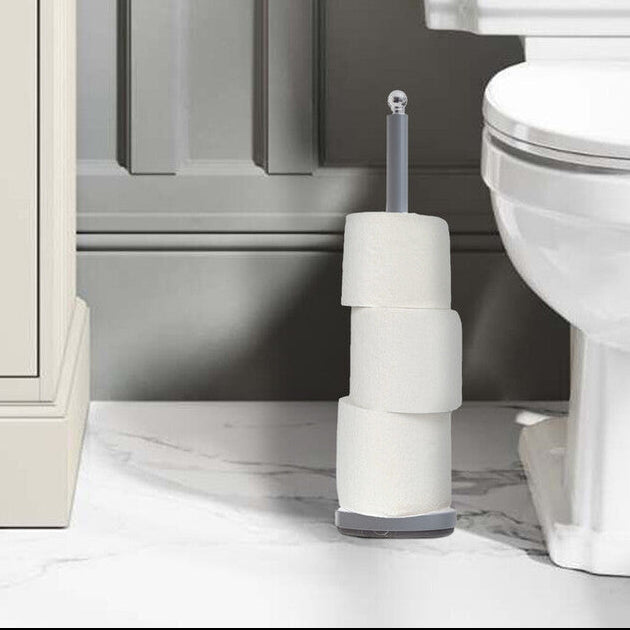 White toilet in a bathroom setting with a sink and cleaning brush.