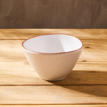 White ceramic bowl with a red rim on a wooden surface