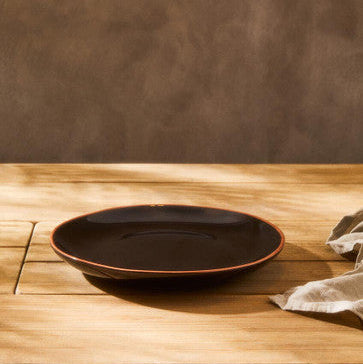Black plate on a wooden table with a brown background