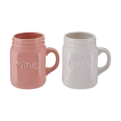 Two ceramic mugs, one pink and one white, with &