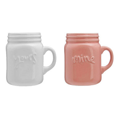 Two ceramic mugs, one white and one pink, with &