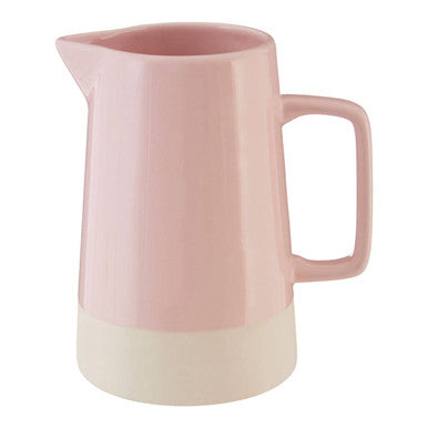Pink ceramic pitcher with a white base on a white background