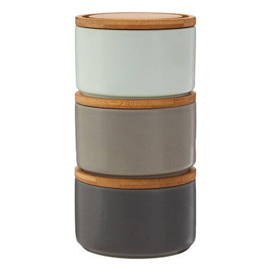 Stack of three ceramic containers with wooden lids on a white background