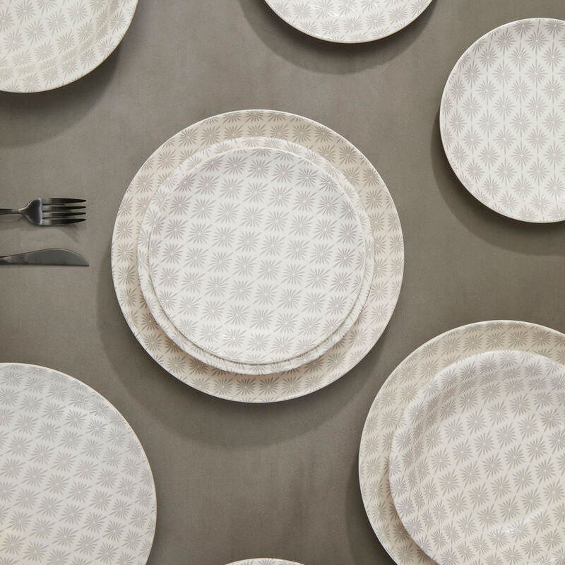 Set of white textured plates and silverware on a brown surface