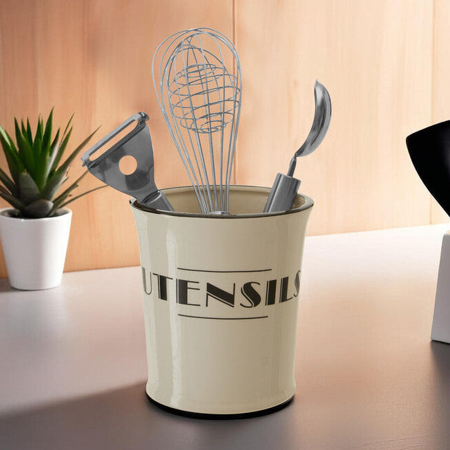 Beige utensil holder with kitchen tools on a wooden surface