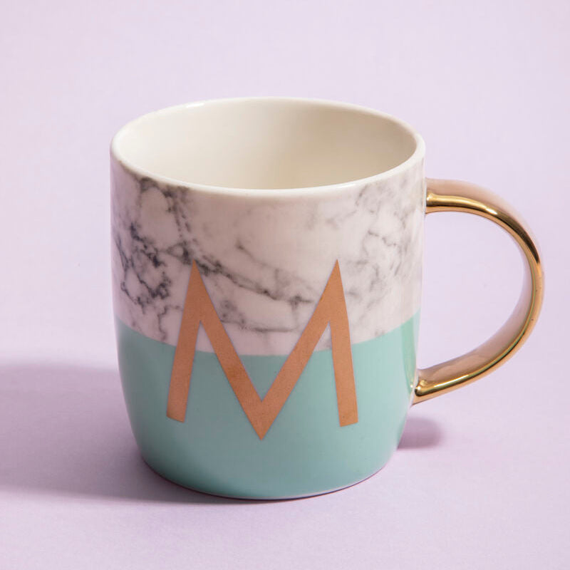 Marble-patterned mug with gold handle and letter &