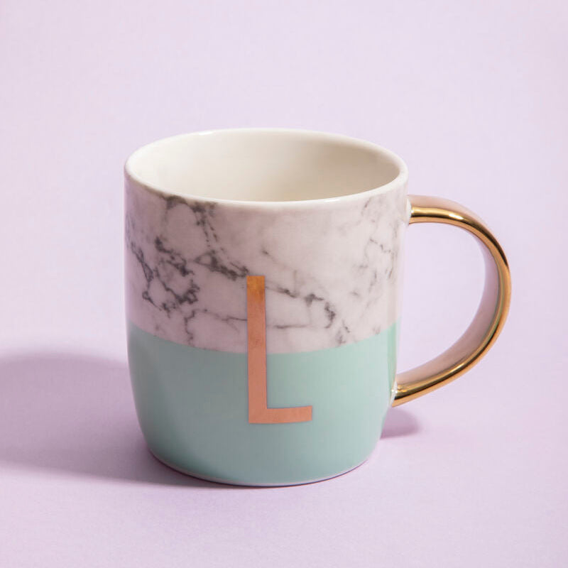 Marble-patterned mug with gold handle and letter &