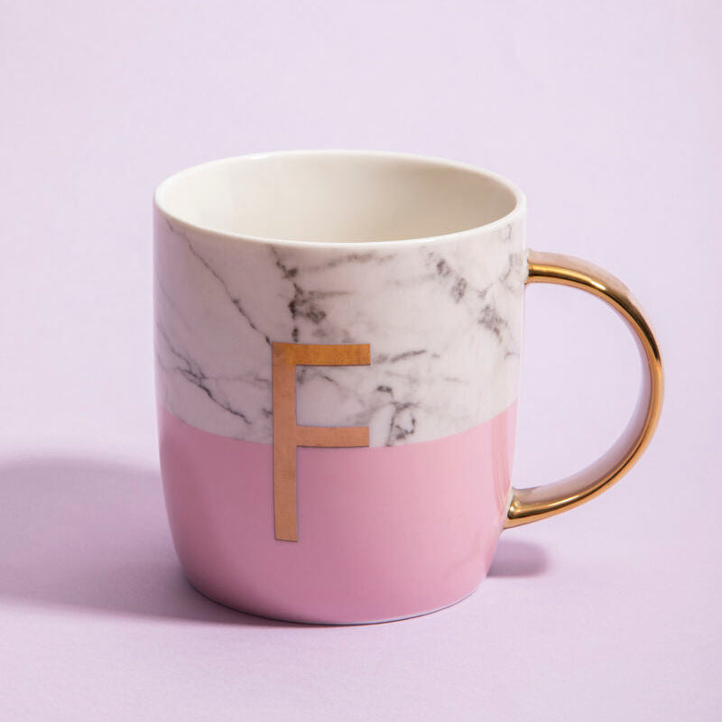 Pink mug with gold handle and letter &