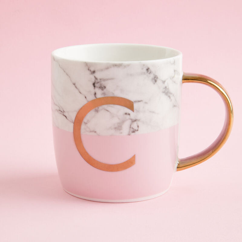 Marble-patterned mug with a gold handle and letter &