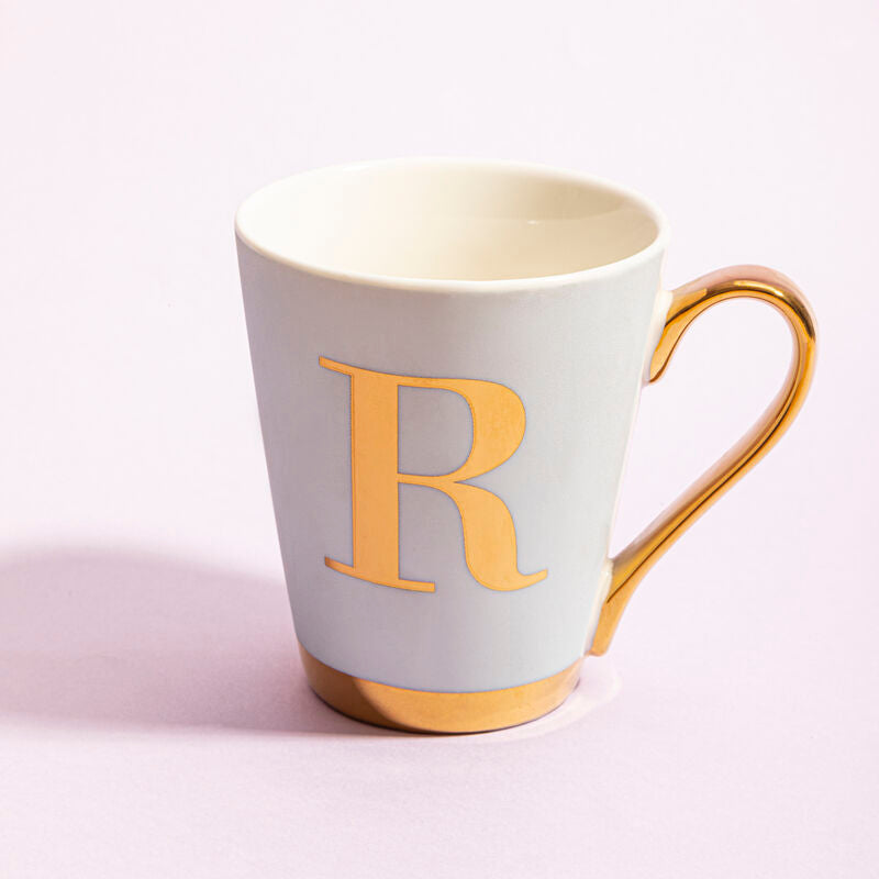 White mug with gold handle and letter &