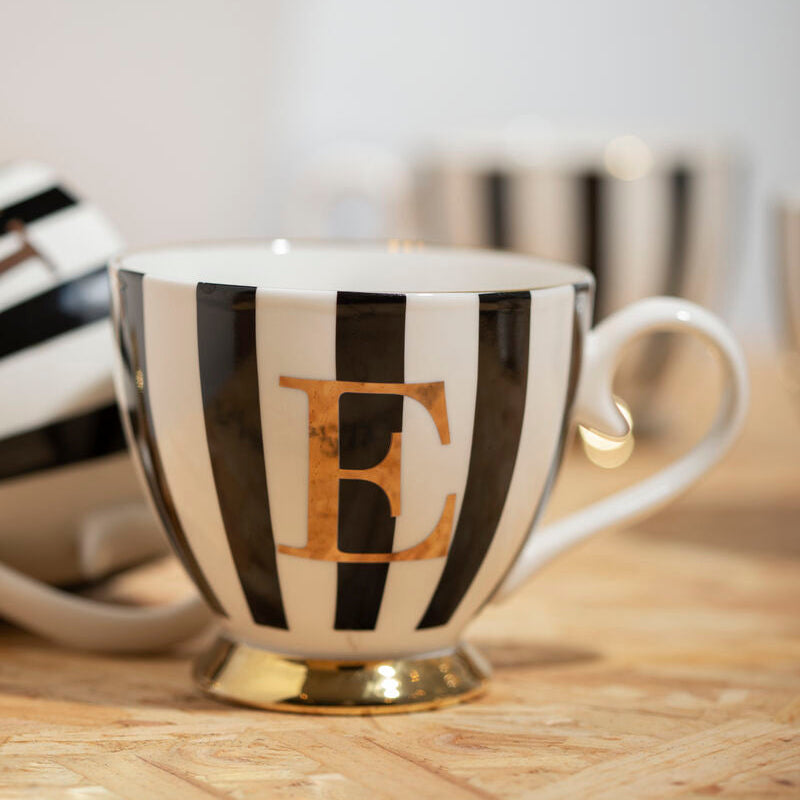 Teacup with black and white stripes and a gold letter &