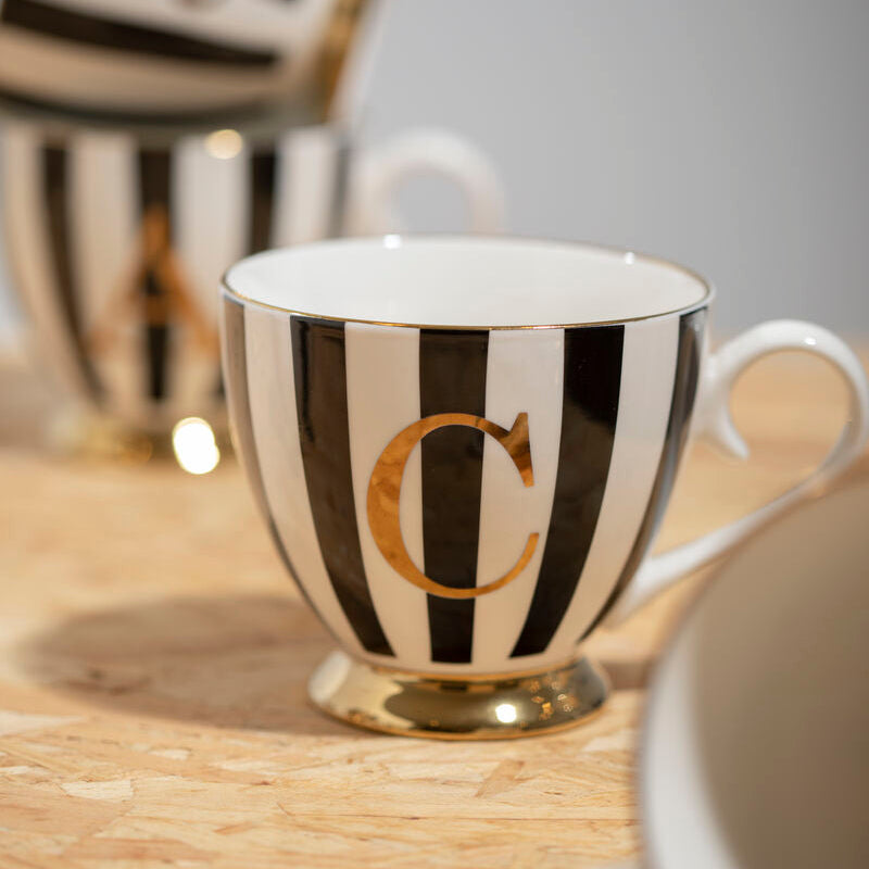 Black and white striped mug with gold letter &