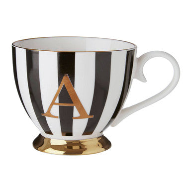 Black and white striped mug with gold base and letter &