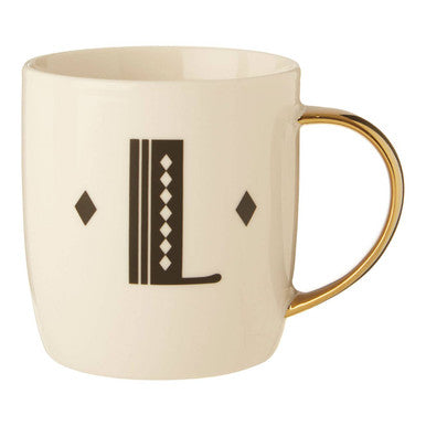 Beige mug with gold handle featuring a decorative letter &