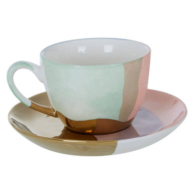 Ceramic cup and saucer with geometric design on a white background