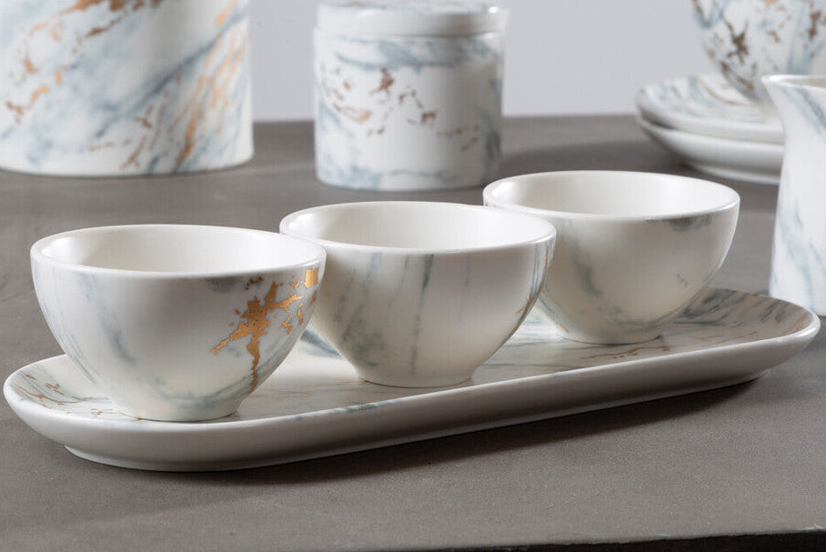 Marble-patterned ceramic tea set on a gray surface