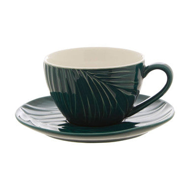 Teal ceramic cup and saucer with leaf pattern on a white background