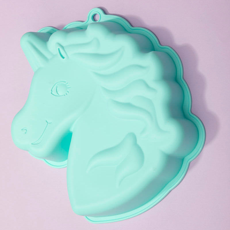 Mint green unicorn-shaped cake mold on a light purple background