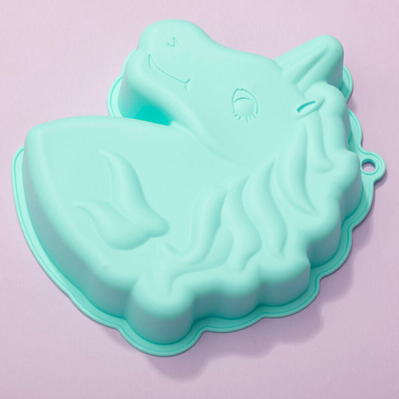 Mint green unicorn-shaped cake mold on a light purple background