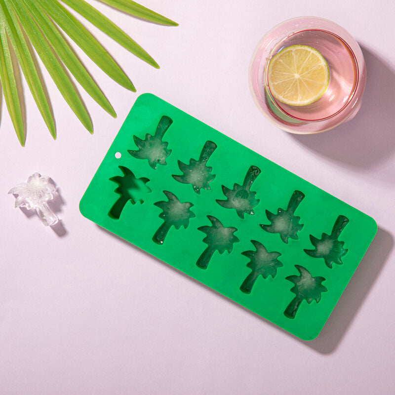 Green ice cube tray with palm tree molds on a light purple background
