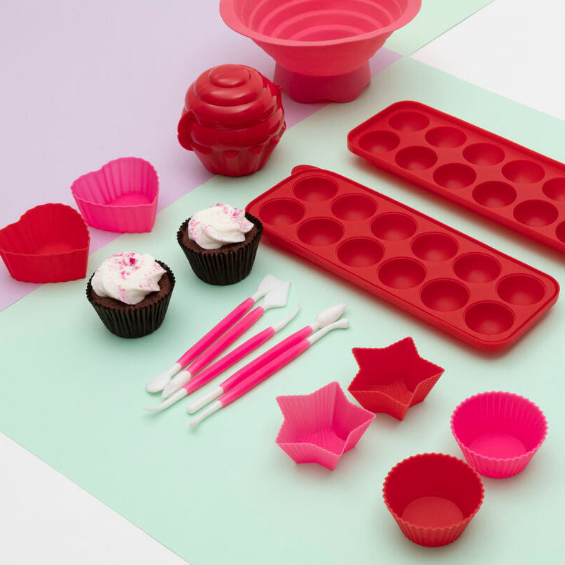 Set of red and pink silicone baking molds on a light green surface