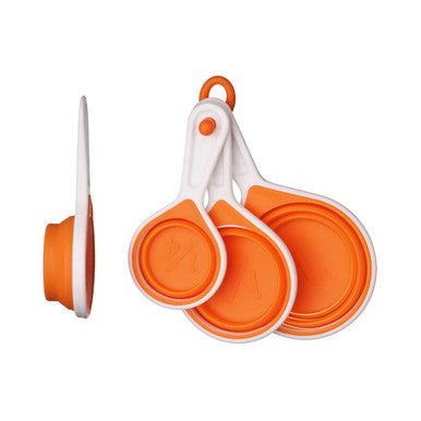 Set of orange and white collapsible measuring cups on a white background