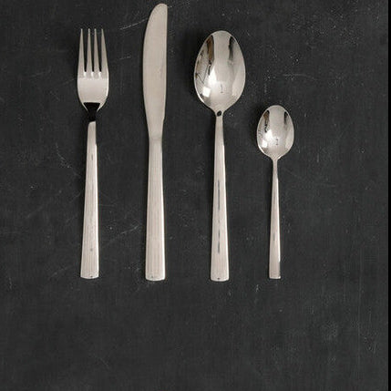 Set of gold and black flatware on a dark surface