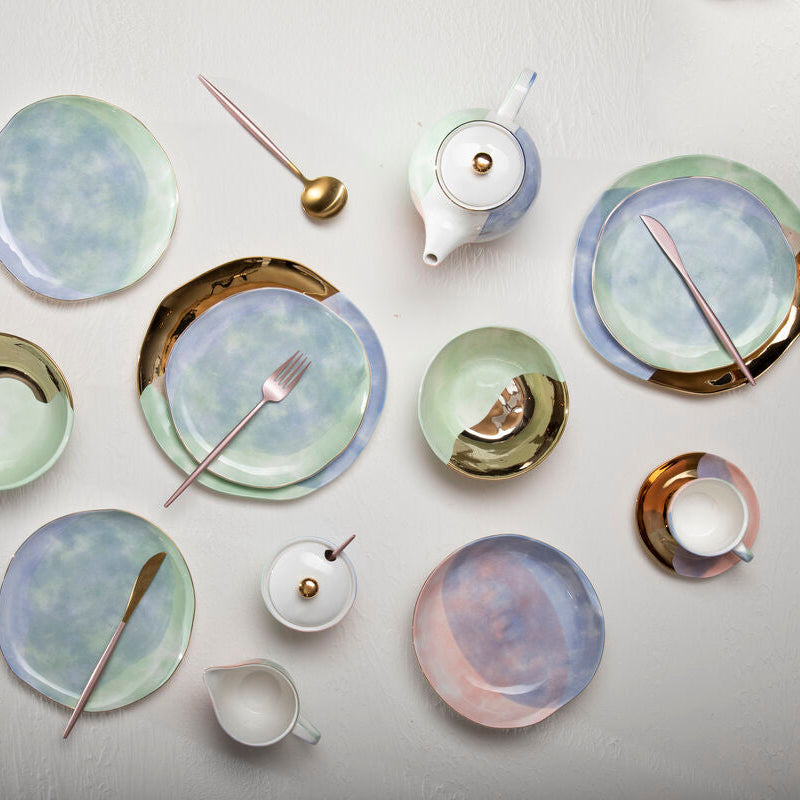 Collection of ceramic plates and teapots on a light gray background