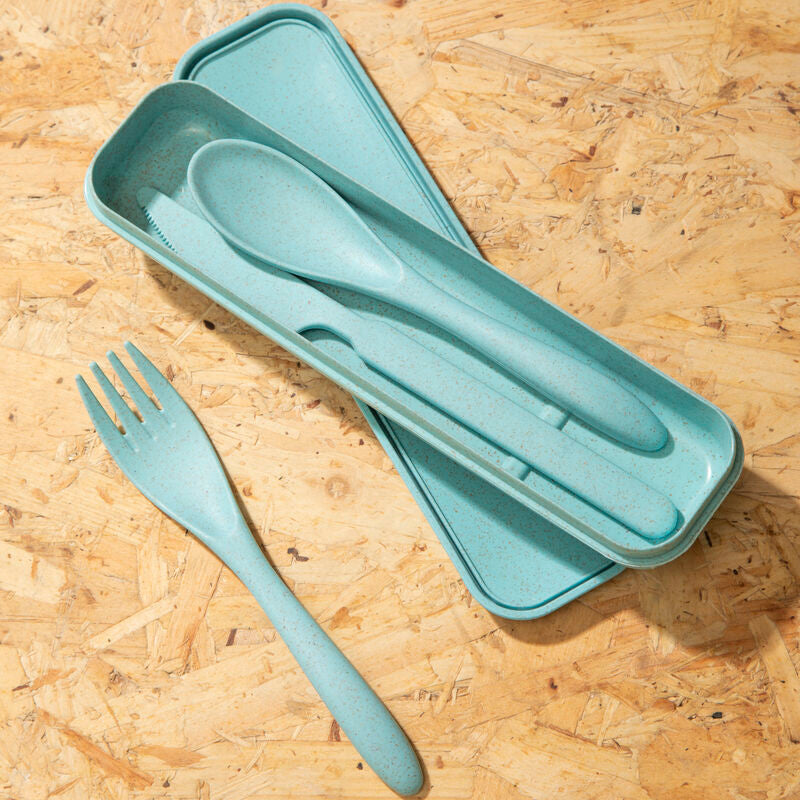 Set of light blue cutlery including fork, knife, and spoon in a case on a wooden surface.