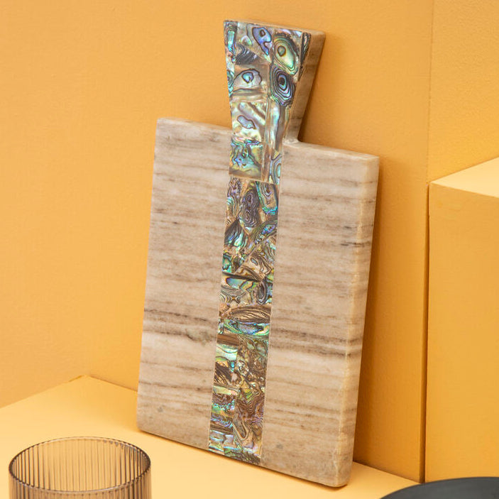 Decorative wall art with abalone shell inlay on a yellow background