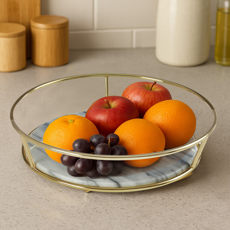 Fruit bowl with oranges, apples, and grapes on a kitchen counter