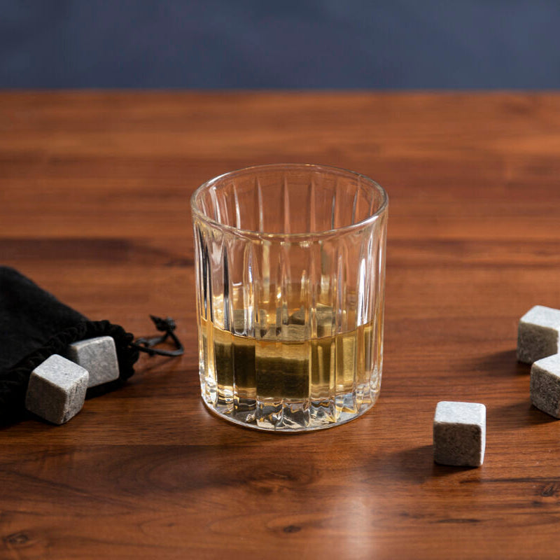 Glass of whiskey with whiskey stones on a wooden table